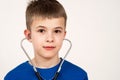 Child boy playing doctor with stethoscope in ears. Pediatric, healthcare and people concept