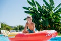 Child boy is playing with an inflatable wheel in a pool on Corfu, Royalty Free Stock Photo