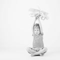 Child boy playing with paper toy airplane sitting on the floor a Royalty Free Stock Photo