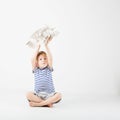 Child boy playing with paper toy airplane sitting on the floor a Royalty Free Stock Photo