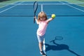 Child boy playing tennis on outdoor court. Little girl with tennis racket and ball in sport club. Active exercise for Royalty Free Stock Photo