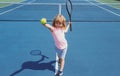 Child boy playing tennis on outdoor court. Little girl with tennis racket and ball in sport club. Active exercise for Royalty Free Stock Photo