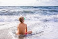 Child boy playing in the waves on the beach in summer sunset, kid watching sea waves and having fun Royalty Free Stock Photo