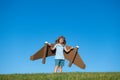 Child boy plays in an astronaut dreams of space. Happy child play with toy plane cardboard wings against blue sky. Kid Royalty Free Stock Photo