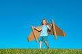 Child boy plays in an astronaut dreams of space. Happy child play with toy plane cardboard wings against blue sky. Kid Royalty Free Stock Photo