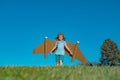 Child boy plays in an astronaut dreams of space. Happy child play with toy plane cardboard wings against blue sky. Kid Royalty Free Stock Photo