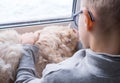 A child, a boy plays with his favorite fluffy red cat by the window. A child strokes a cat. Attachment between children Royalty Free Stock Photo