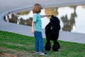 Child boy with poodle dog walking outdoor. Kid playing with puppy. Children with pet friend. Royalty Free Stock Photo