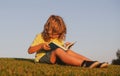 Child boy is reading a book on the spring park. Relaxing on the grass in the garden. Outdoor education. Kids success Royalty Free Stock Photo