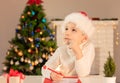 Child boy in red Santa hat writing a letter to Santa Claus. Christmas or New Year cozy holidays concept. Xmas time Royalty Free Stock Photo