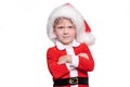 A child boy in a red suit and a santa claus hat stands with his hands on his chest. Positive story about Christmas and New Year Royalty Free Stock Photo