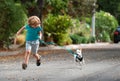 Child boy run with dog in leash walking outdoor. Kid playing with puppy. Children with pet friend. Royalty Free Stock Photo