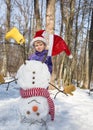 Child boy in Santa hat and homemade funny snowman standing upside down on his head Royalty Free Stock Photo