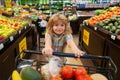 Child boy is shopping in a supermarket. Child buying fruit in supermarket. Kid buy fresh vegetable in grocery store Royalty Free Stock Photo