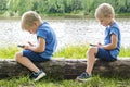 Child boy sits slouching hunched back bent,neck and straight,looks phone,over device.correct