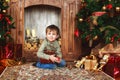 Child boy sitting under the Christmas tree with gift box Royalty Free Stock Photo