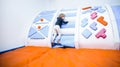 Child boy son plays in the children`s room with inflatable trampolines, climbs the slide active game indoor