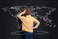 Child boy student looking at map of Earth on chalkboard background and learning geography Royalty Free Stock Photo