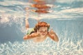 Child boy swimming underwater in swimming pool. Funny kids boy play and swim in the sea water. Royalty Free Stock Photo