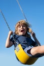 Child boy on swing. Little kid swinging on playground. Happy cute excited child on swing. Cute child swinging on a swing Royalty Free Stock Photo