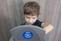 Child boy throwing paper to waste bin for paper at home