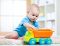 Child boy toddler playing with toy car in nursery Royalty Free Stock Photo