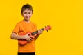 Child boy with ukulele in studio Royalty Free Stock Photo