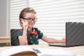 Child boy using a laptop and study online lesson. Pupil at school. Cute child using laptop computer, studying online.