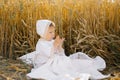 A child boy in white clothes is relaxing in the fresh air in a field Royalty Free Stock Photo