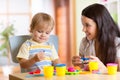 Child boy and woman play colorful clay toy at Royalty Free Stock Photo