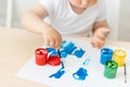 Child boy 2 years old sitting at a table on a white isolated background and paints, early development, close-up drawing, place for Royalty Free Stock Photo