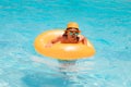 Child boy 7, 8, 9 years old swim on floating ring in swimming pool. Kids summer funny face. Royalty Free Stock Photo