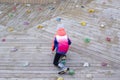 a child in a bright pink jacket is climbing a wooden wall Royalty Free Stock Photo