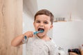 Child brushing teeth. Kids tooth brush and paste. Little funny baby boy brushing his teeth in modern bathroom on sunny Royalty Free Stock Photo