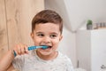 Child brushing teeth. Kids tooth brush and paste. Little funny baby boy brushing his teeth in modern bathroom on sunny Royalty Free Stock Photo