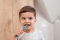 Child brushing teeth. Kids tooth brush and paste. Little funny baby boy brushing his teeth in modern bathroom on sunny Royalty Free Stock Photo