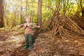 Child with brushwood pile in the forest build hut of branches, Royalty Free Stock Photo