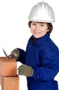 Child builder making a wall of bricks