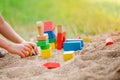 Child building house from wooden blocks in sandbox in summer Royalty Free Stock Photo