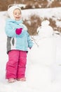 Child building snowman. Royalty Free Stock Photo