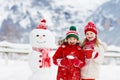 Child building snowman. Kids build snow man Royalty Free Stock Photo