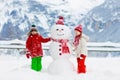 Child building snowman. Kids build snow man Royalty Free Stock Photo