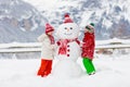 Child building snowman. Kids build snow man Royalty Free Stock Photo