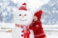 Child building snowman. Kids build snow man Royalty Free Stock Photo