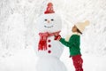 Child building snowman. Kids build snow man Royalty Free Stock Photo