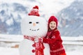 Child building snowman. Kids build snow man Royalty Free Stock Photo