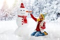 Child building snowman. Kids build snow man Royalty Free Stock Photo