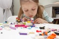 Child builds with constructor bricks, plays with toys