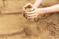 A child builds sand castles on the beach in the summer. Sea tour. Child`s hands in the sand. Entertainment in the fresh air. Royalty Free Stock Photo