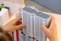 A child builds a toy multi-storey house - simulator of the city and urbanization